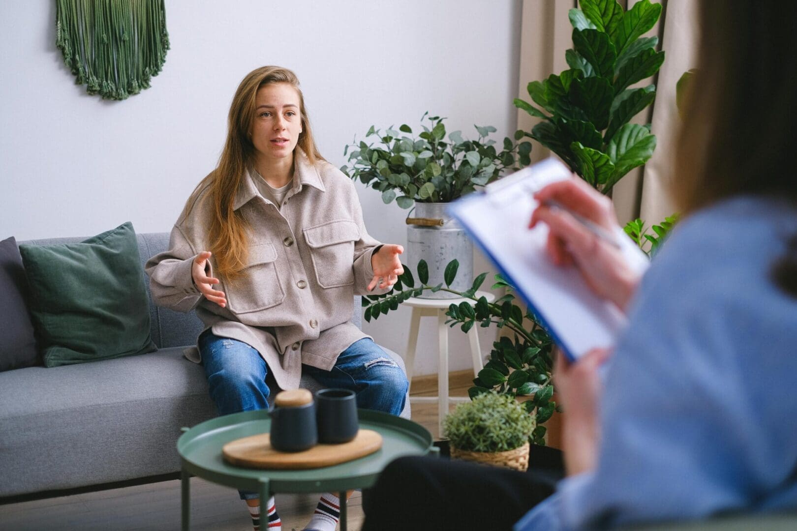 A woman sitting on the couch talking to someone.